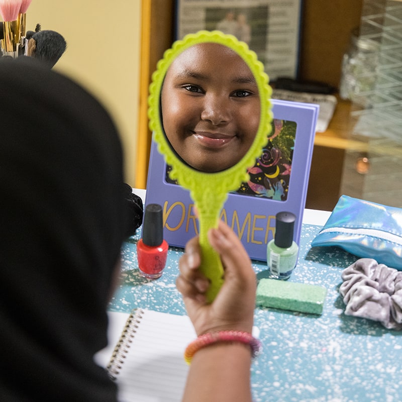 girl smiling into mirror