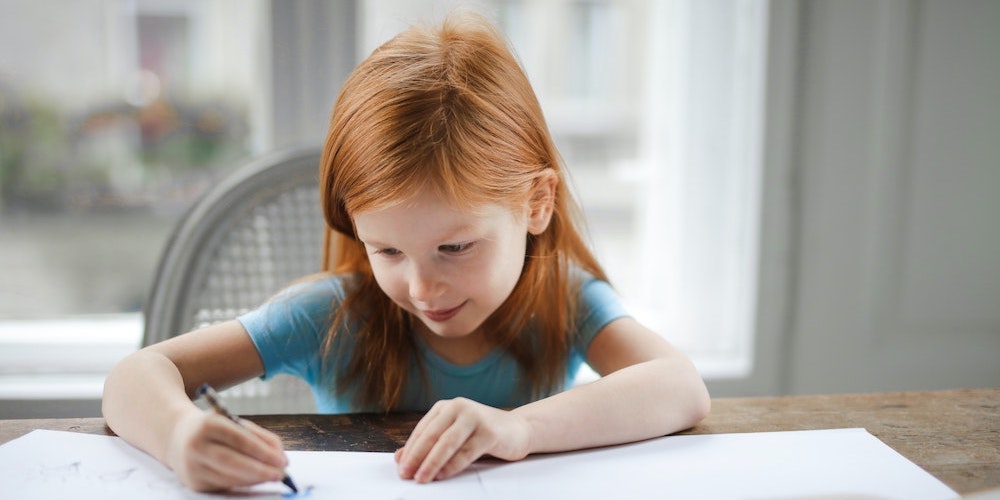 child writing in notebook