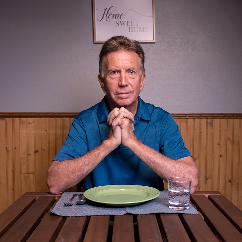 senior man sitting at dinner table