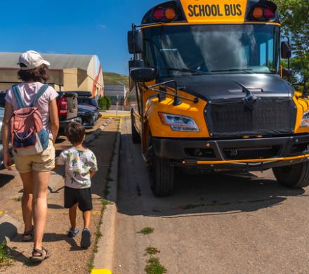 Parent walking child to a school bus